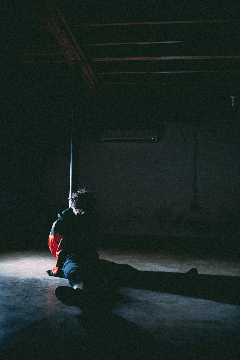 low-light photo of man sitting on floor
