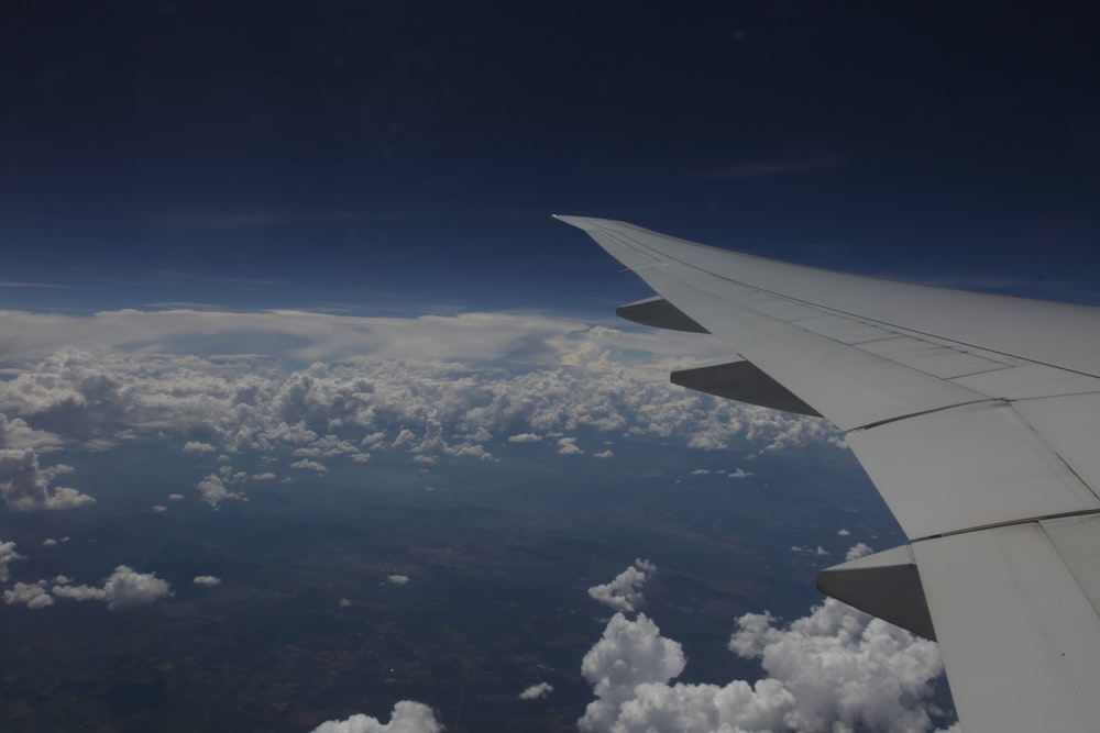 aerial photography of airplane flying over sea of clouds