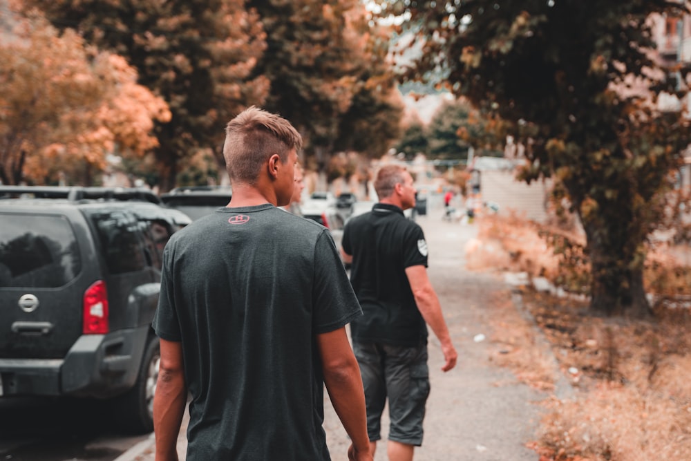 two men standing near vehicle on sidewalk