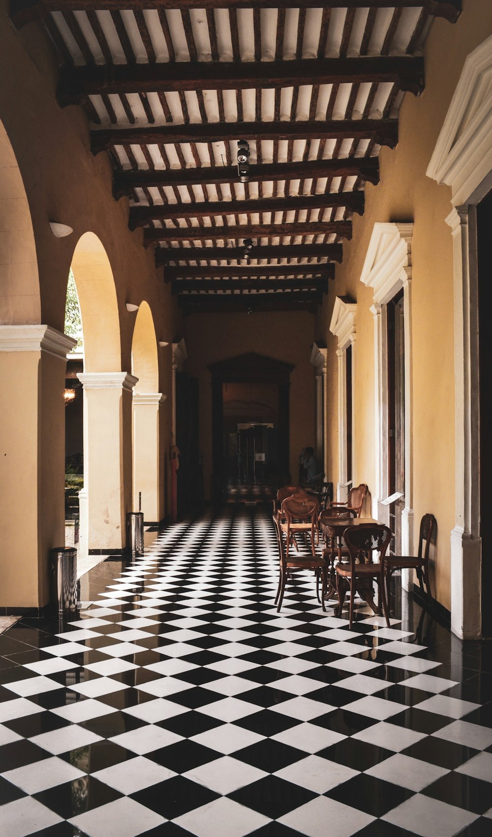 brown concrete pillars and white and black checked tiles