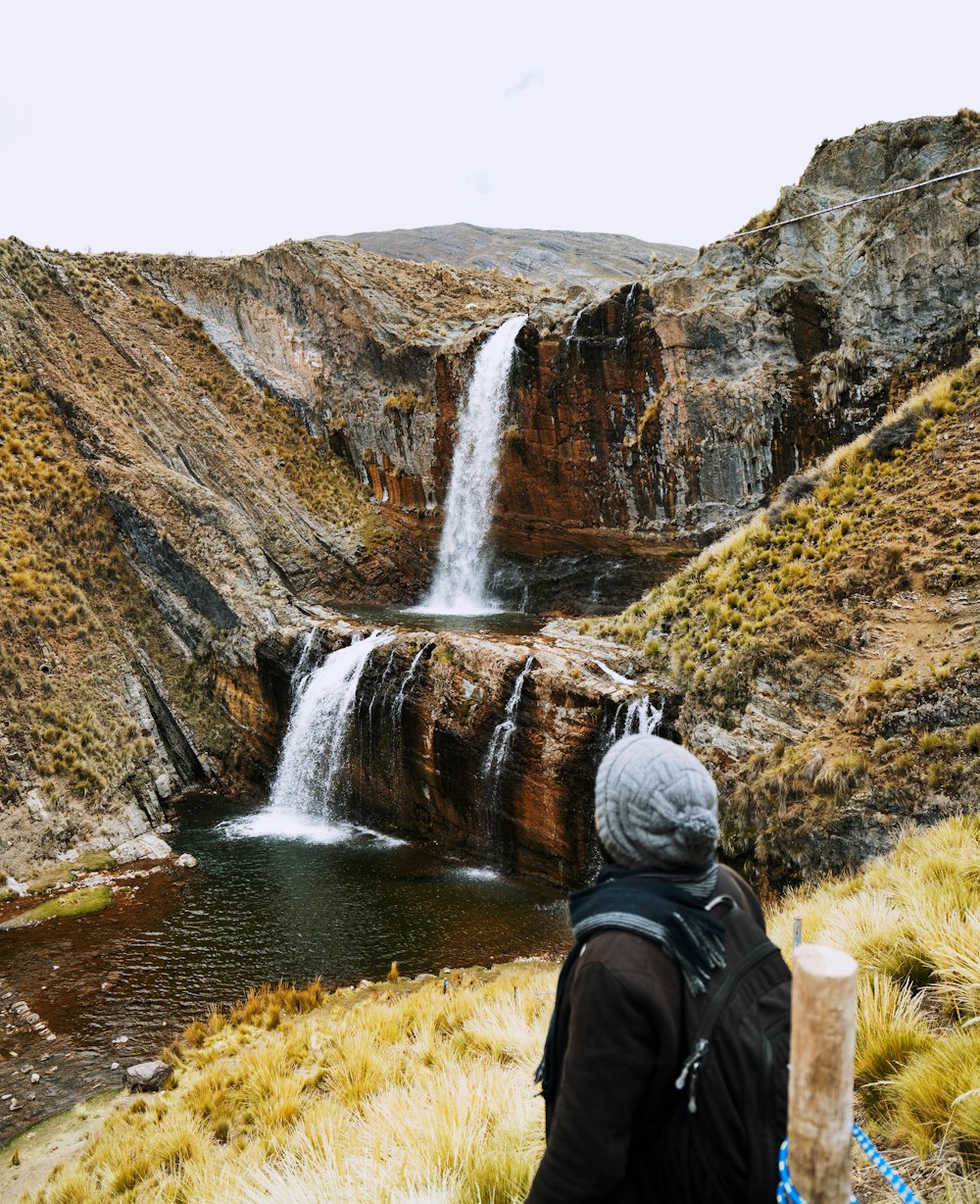 person standing in front of water falls