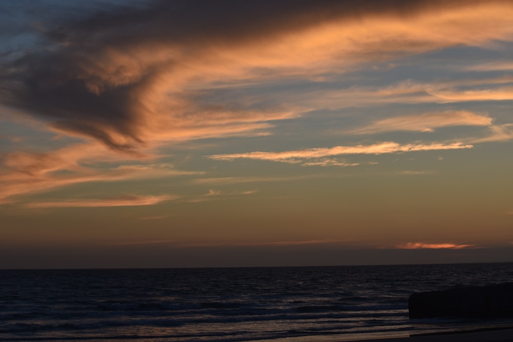 sea waves crashing on shore during golden hour