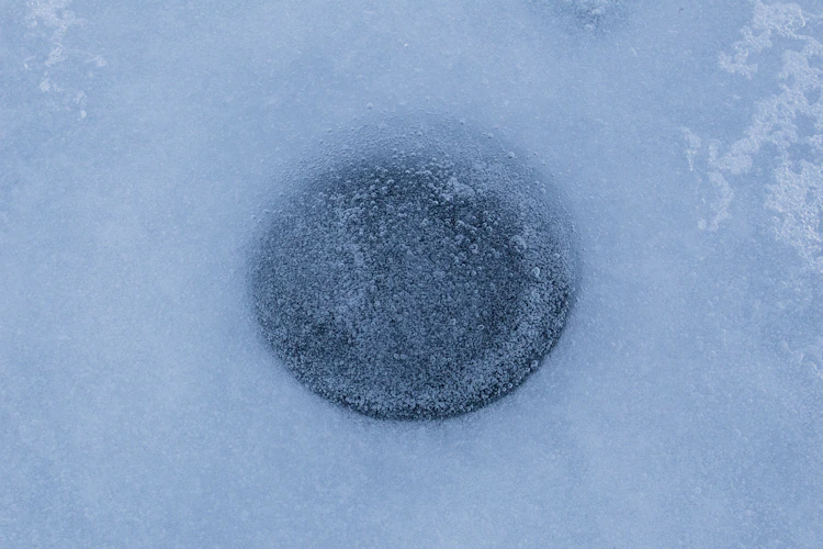 ice fishing hole drilled in the ice