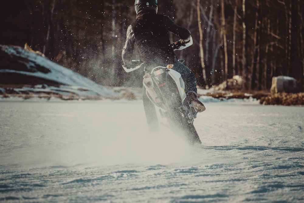 uomo che guida il motociclo sulla neve
