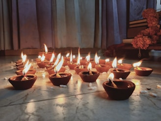 A serene photo of Shri Krishnarjun Bhat consulting ancient astrological texts under soft candlelight.