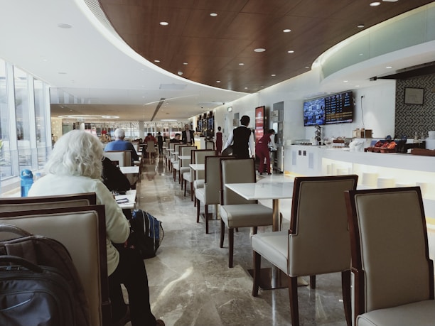 Professional business traveler checking flight details on a tablet in a modern airport lounge.
