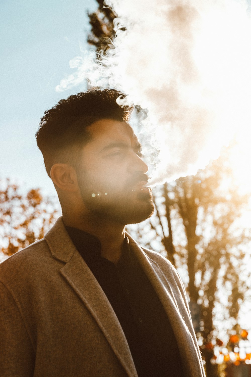 man wearing brown blazer smoking