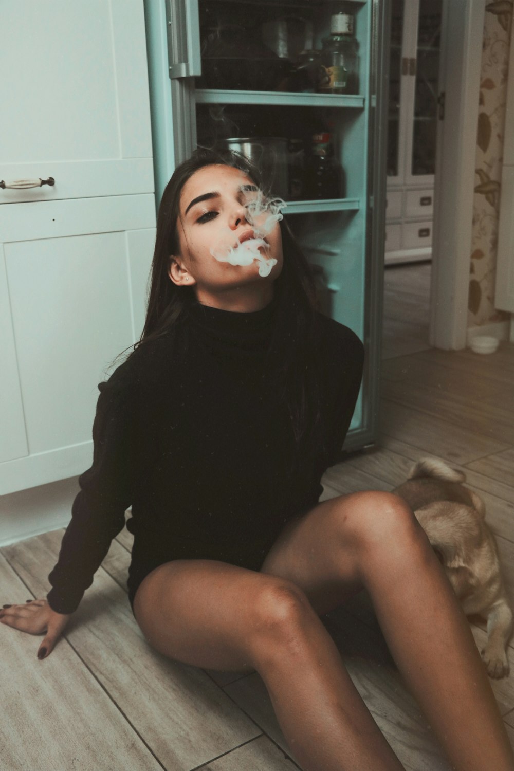 woman sitting on floor while smoking
