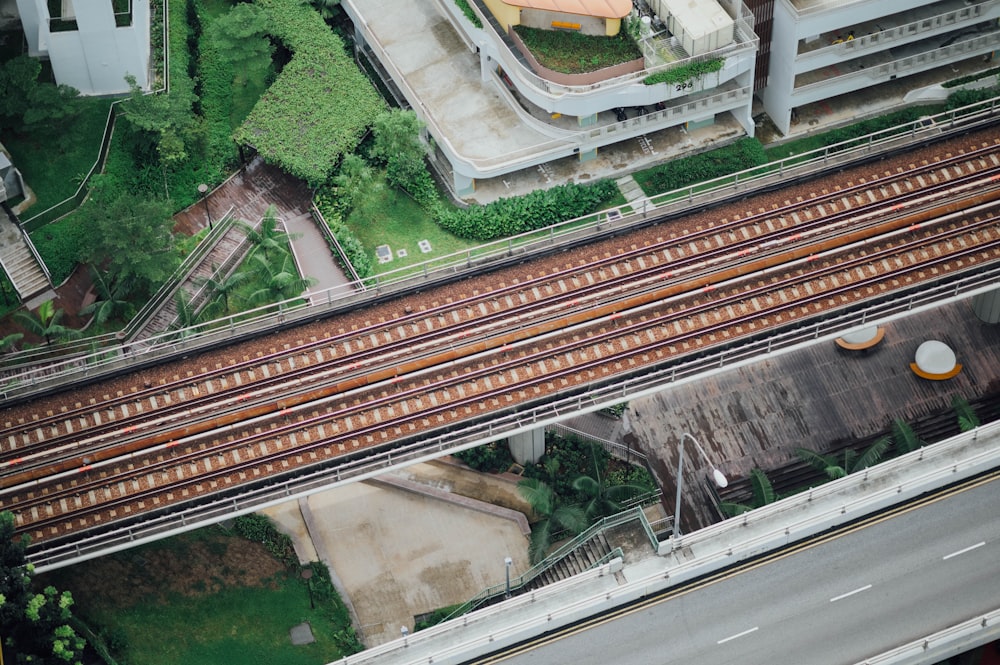 aerial photography of train rails between bridge and building