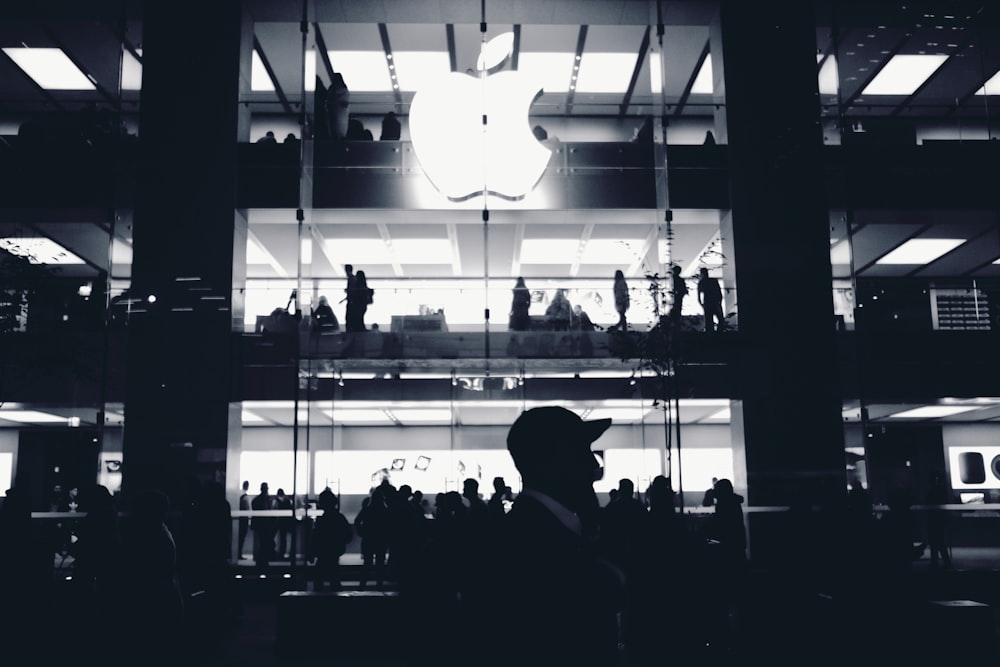 silhouette of man walking near Apple building