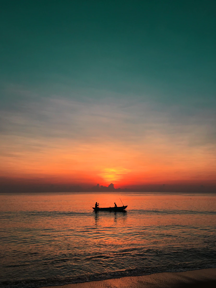 Silhouette of a canoe boat at sunset over the sea