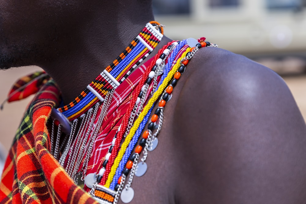 person wearing beaded multicolored necklace in selective focus photography