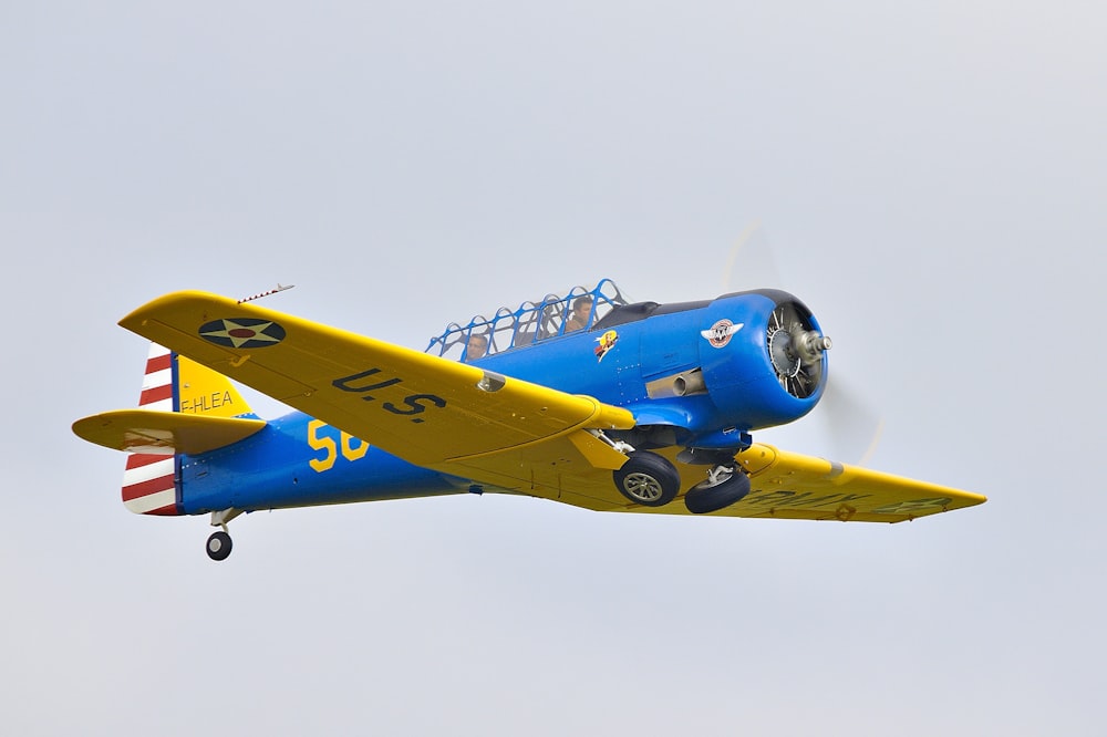 blue and yellow biplane on flight