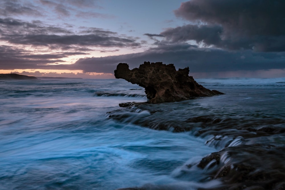 brown rock formation on body of water