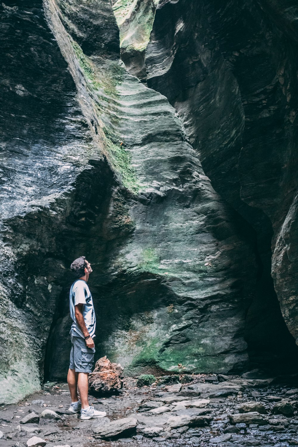 man standing while looking on rock