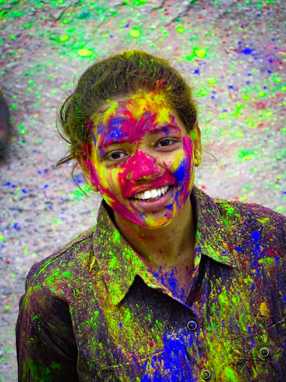 A vibrant portrait of a person celebrating pride with colorful face paint and a joyful expression.