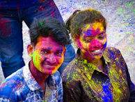 Close-up of joyful faces painted with bright colors during the Andean carnival parade.