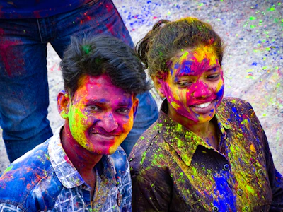 Smiling friends posing with face paint at a lively community fair in Atlanta.