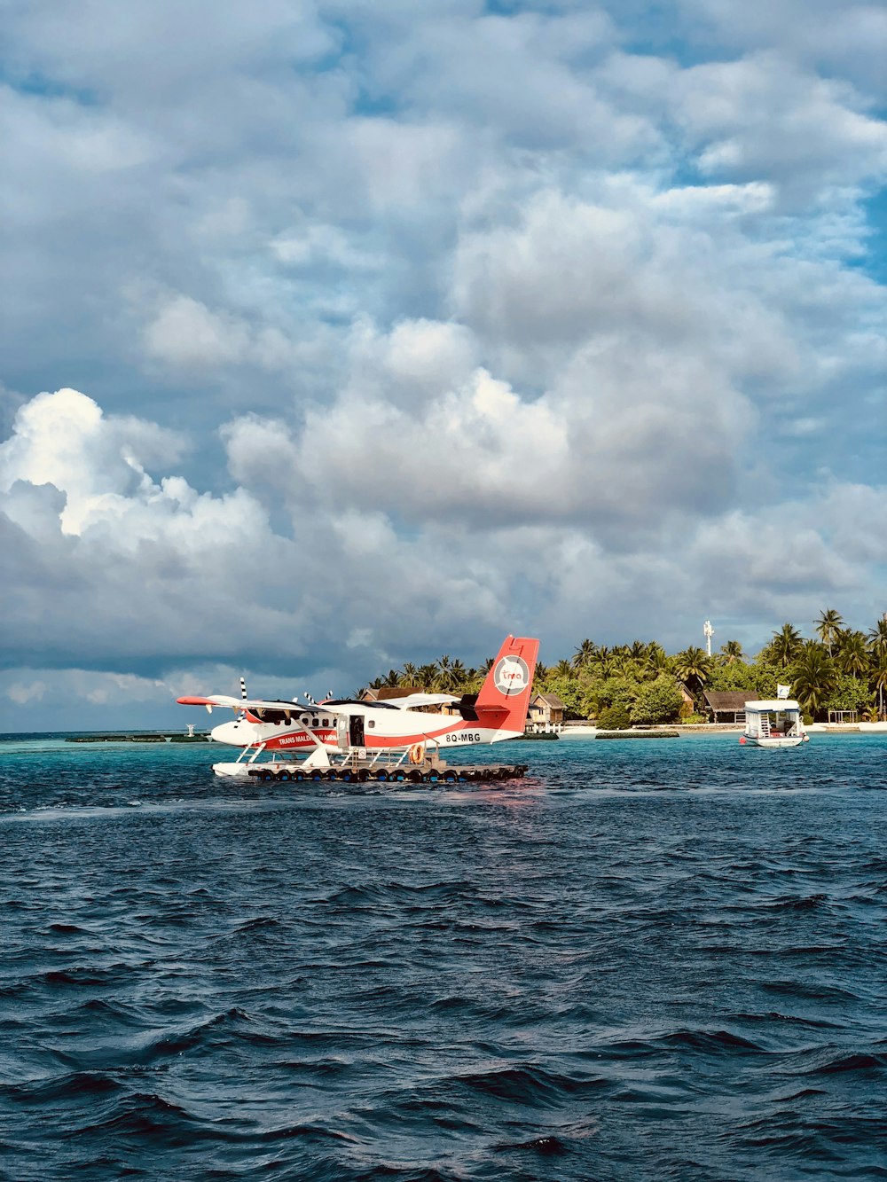 white and red water plane on body of water near seashore