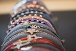Close-up of hands mixing colorful bracelets and rings on a bright background.