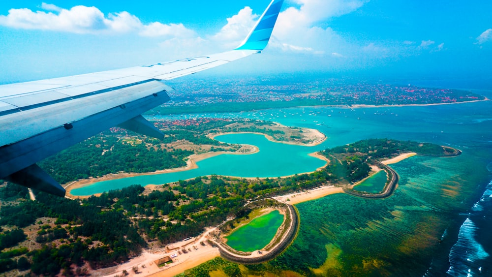 personne à l’intérieur de l’avion volant à haute altitude avec vue sur l’île pendant la journée