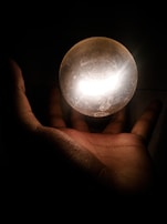 Hands gently holding a sphere of pulsating light energy.
