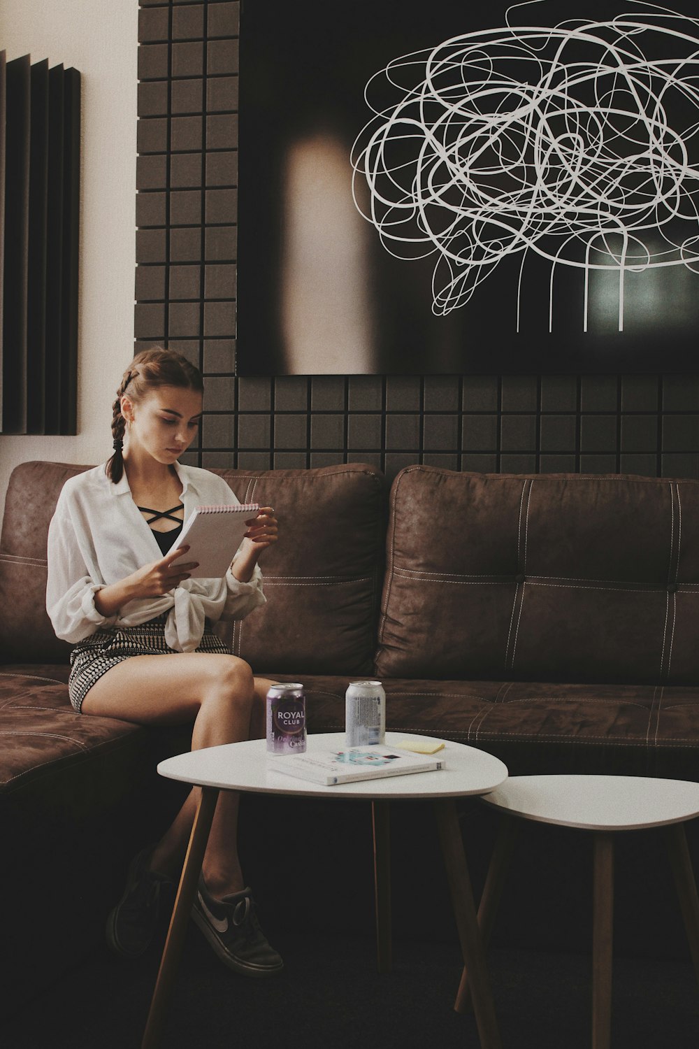 woman sitting on tufted brown padded sofa