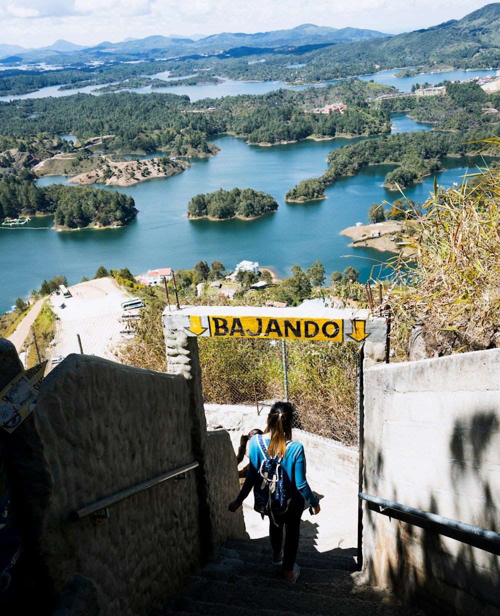 woman using stairs walking down with Bajando signage during daytime