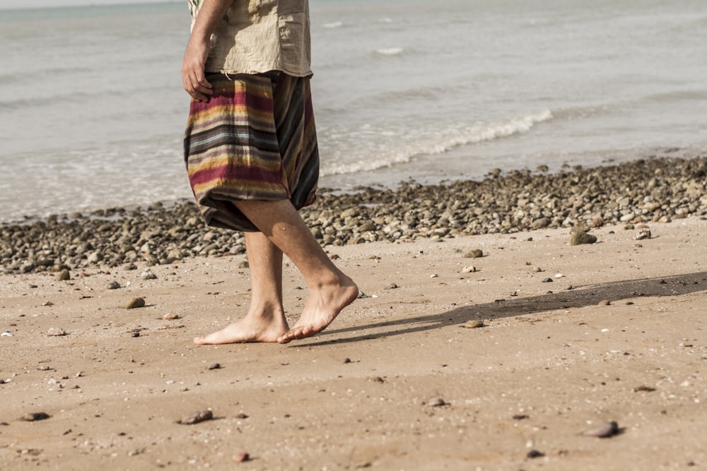 person walking on seashore