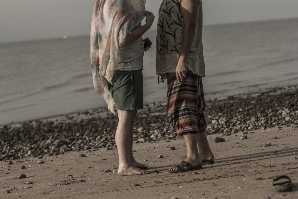 two men standing on shoreline