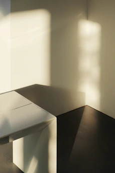 A serene morning light softly illuminating a minimalist art piece on a clean white wall.