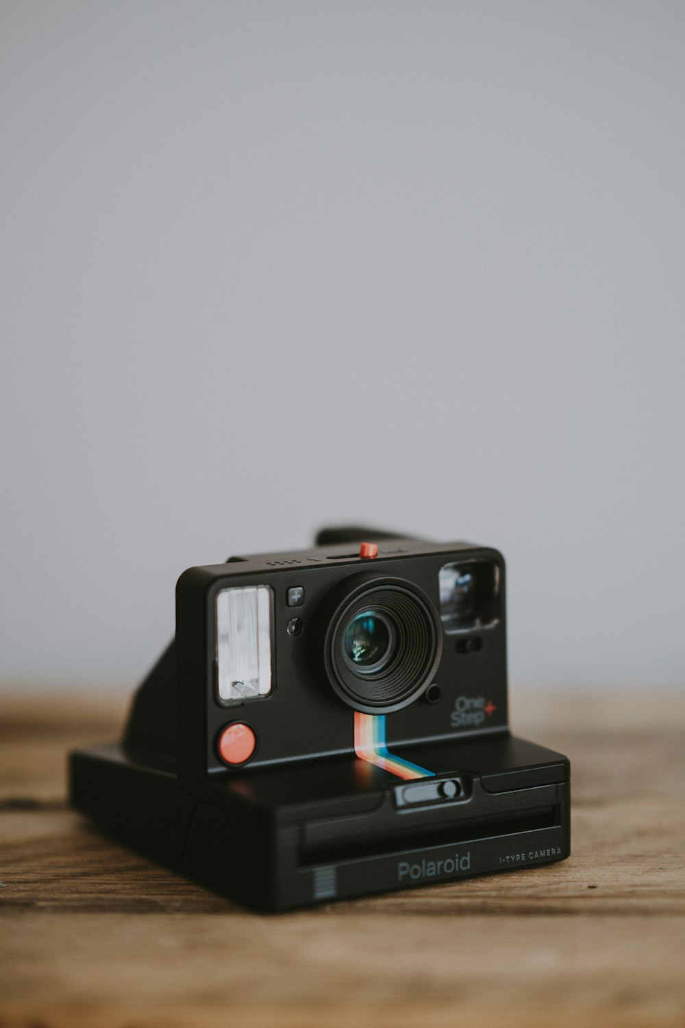 black instant camera on wooden surface