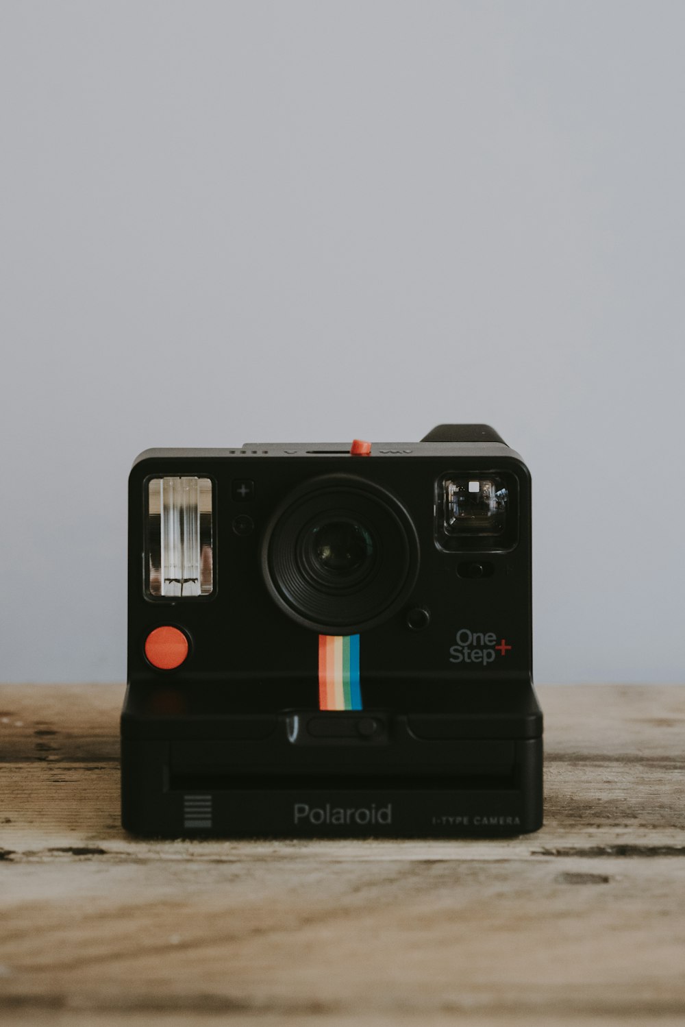 fotocamera istantanea Polaroid One Step+ nera su superficie marrone