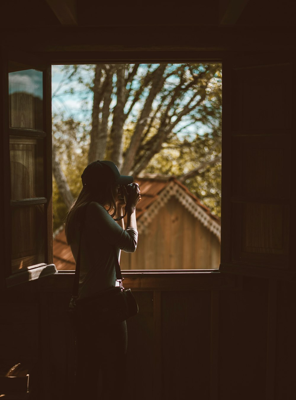 woman taking photo outside window
