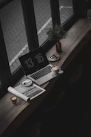 A cozy morning desk setup with a laptop, coffee cup, and soft sunlight streaming in