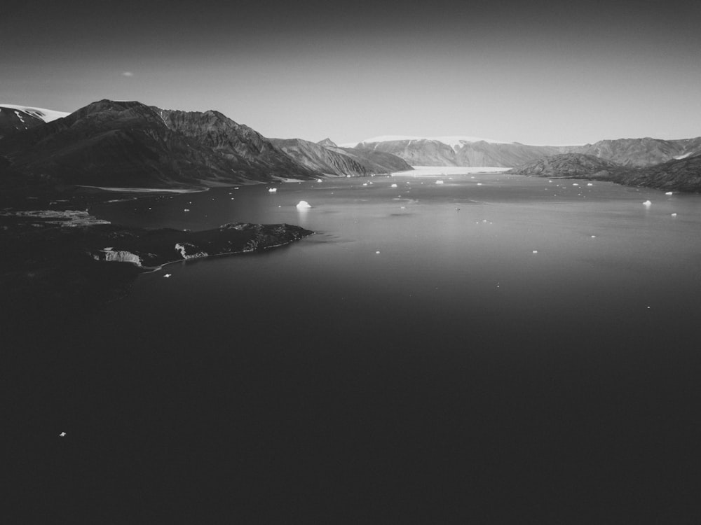 aerial photography of lake overlooking mountain in greyscale photography