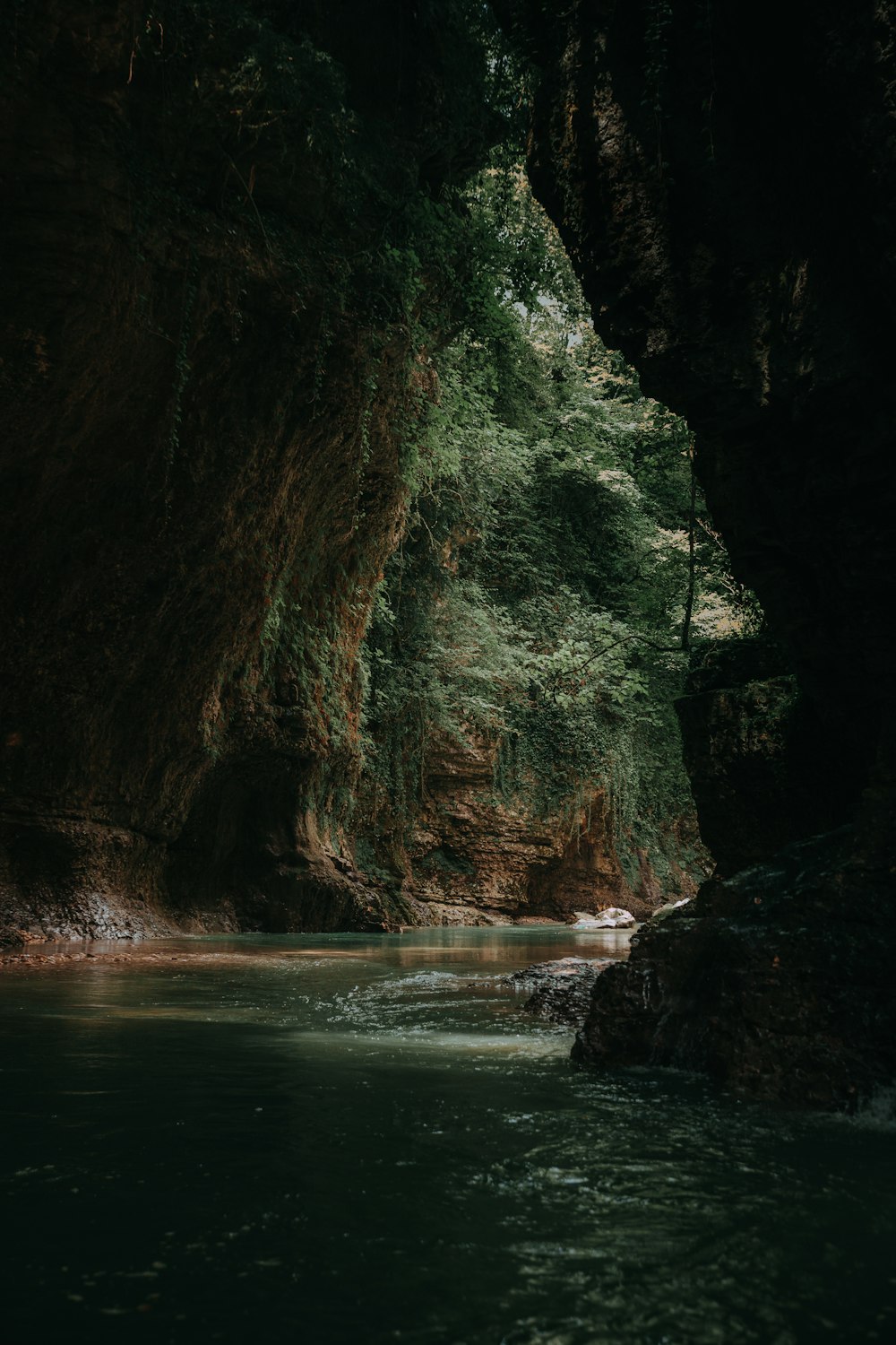 calm body of water inside cave at daytime