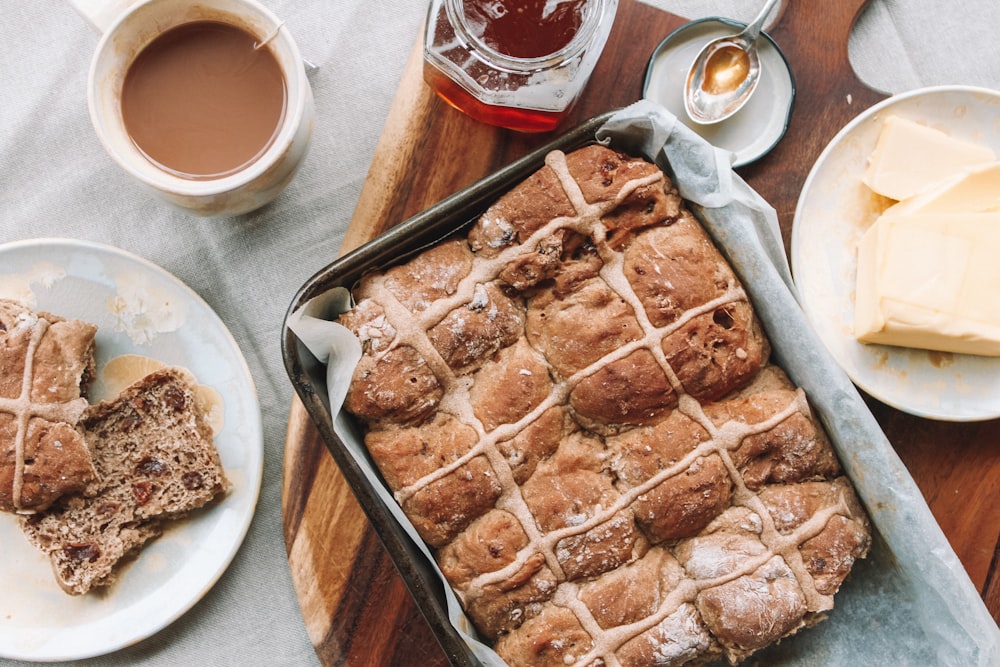 baked bread on pan on top of table beside butter on plate