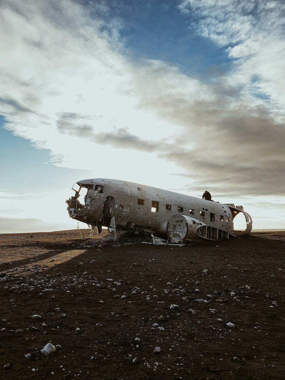wrecked and abandoned airplane on dirt field