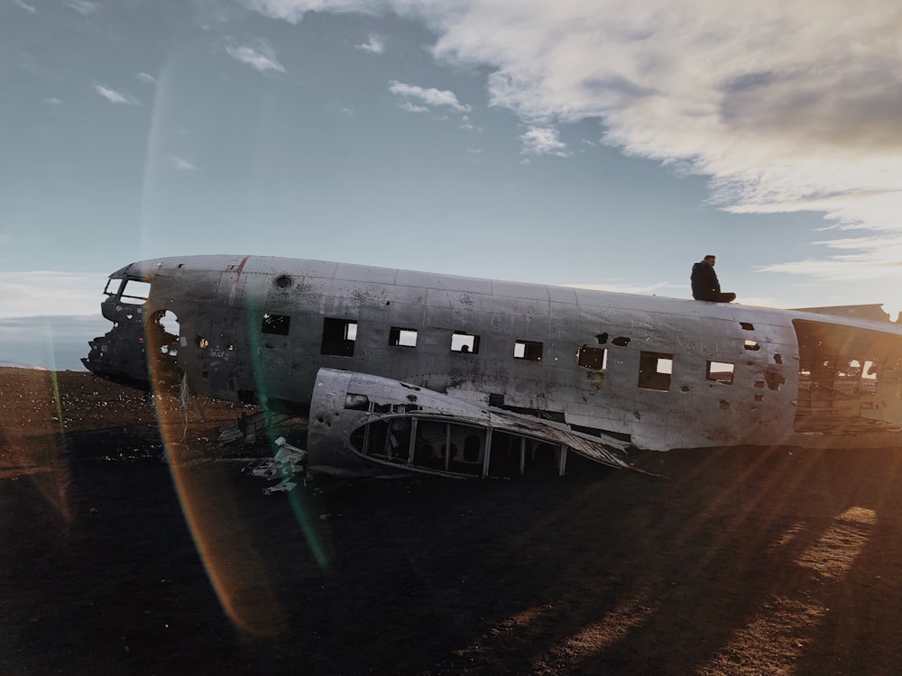 person standing on abandoned crashed plane during daytime