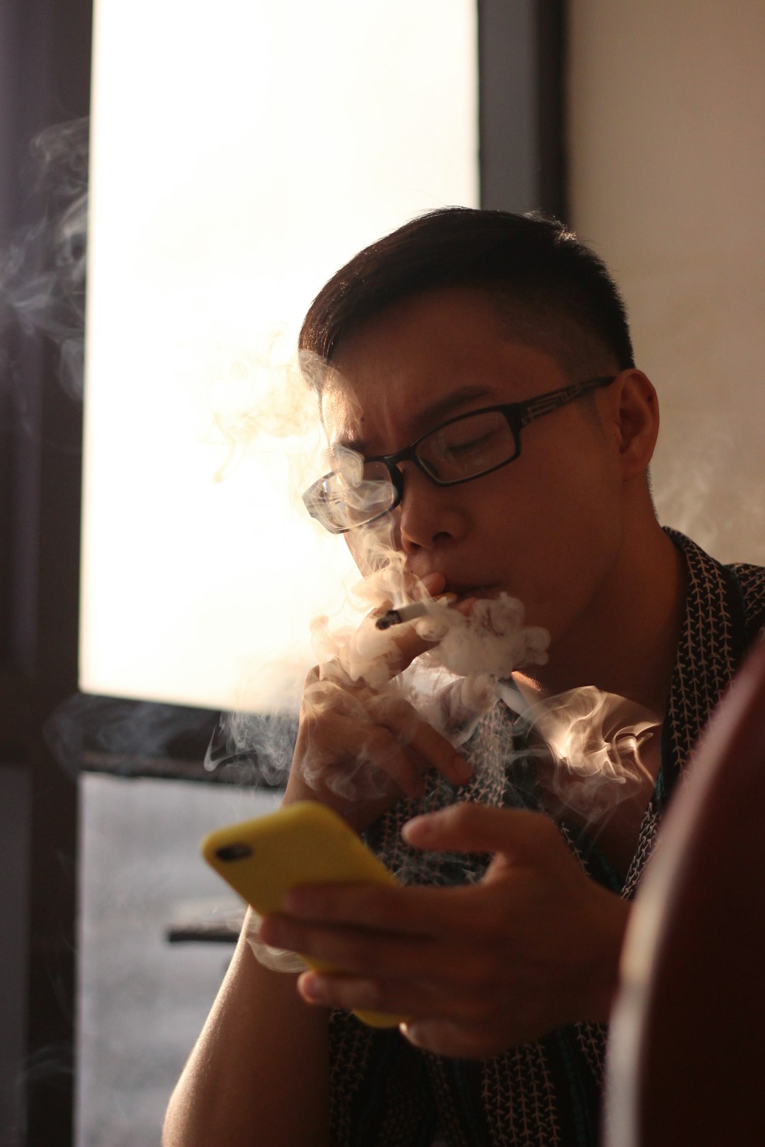 smoking man holding smartphone