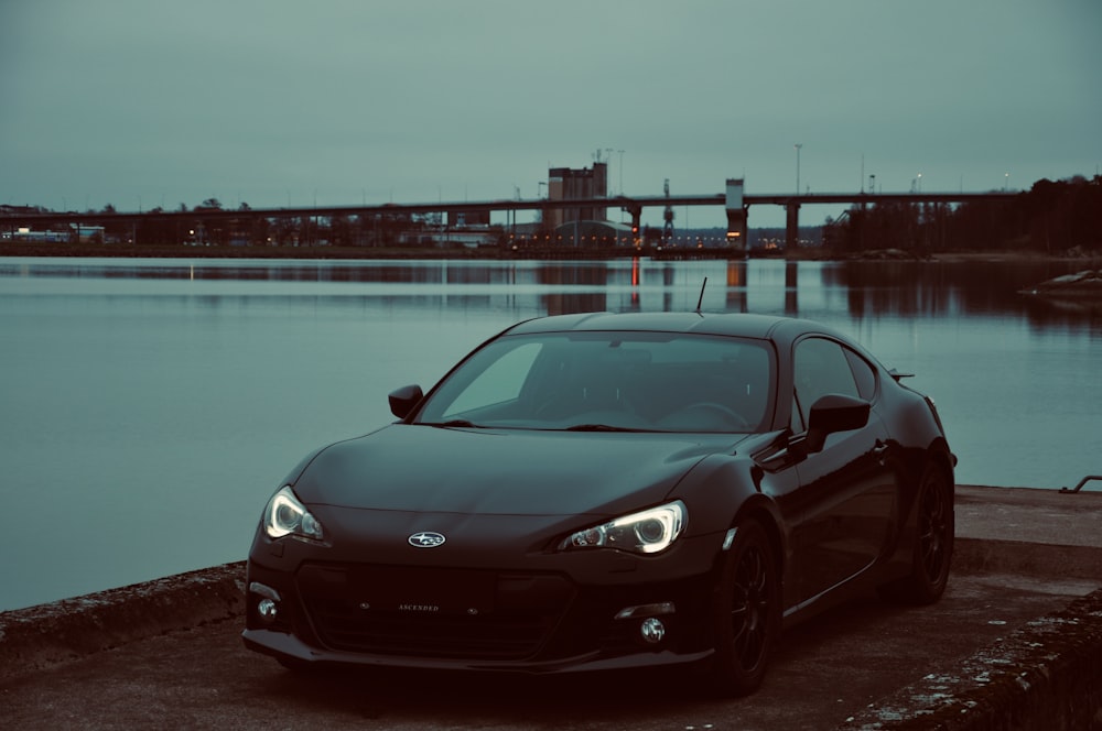 parked black coupe under gray skyu