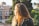woman in black leather jacket near tree and house