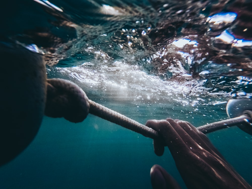 Persona sosteniendo una cuerda bajo el agua