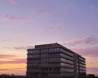 Birla Group headquarters building with bustling employees and a sunrise backdrop.
