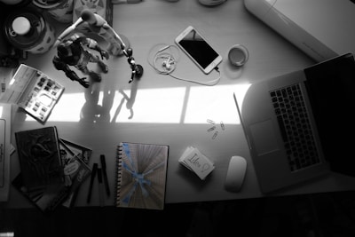 A cozy workspace with a laptop, smartphone, and various small gadgets scattered around, suggesting problem-solving in action.