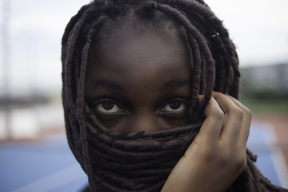 woman covering her face with braided hair