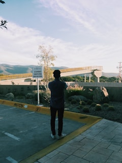 A person taking photos of a vacant land lot under clear sky.