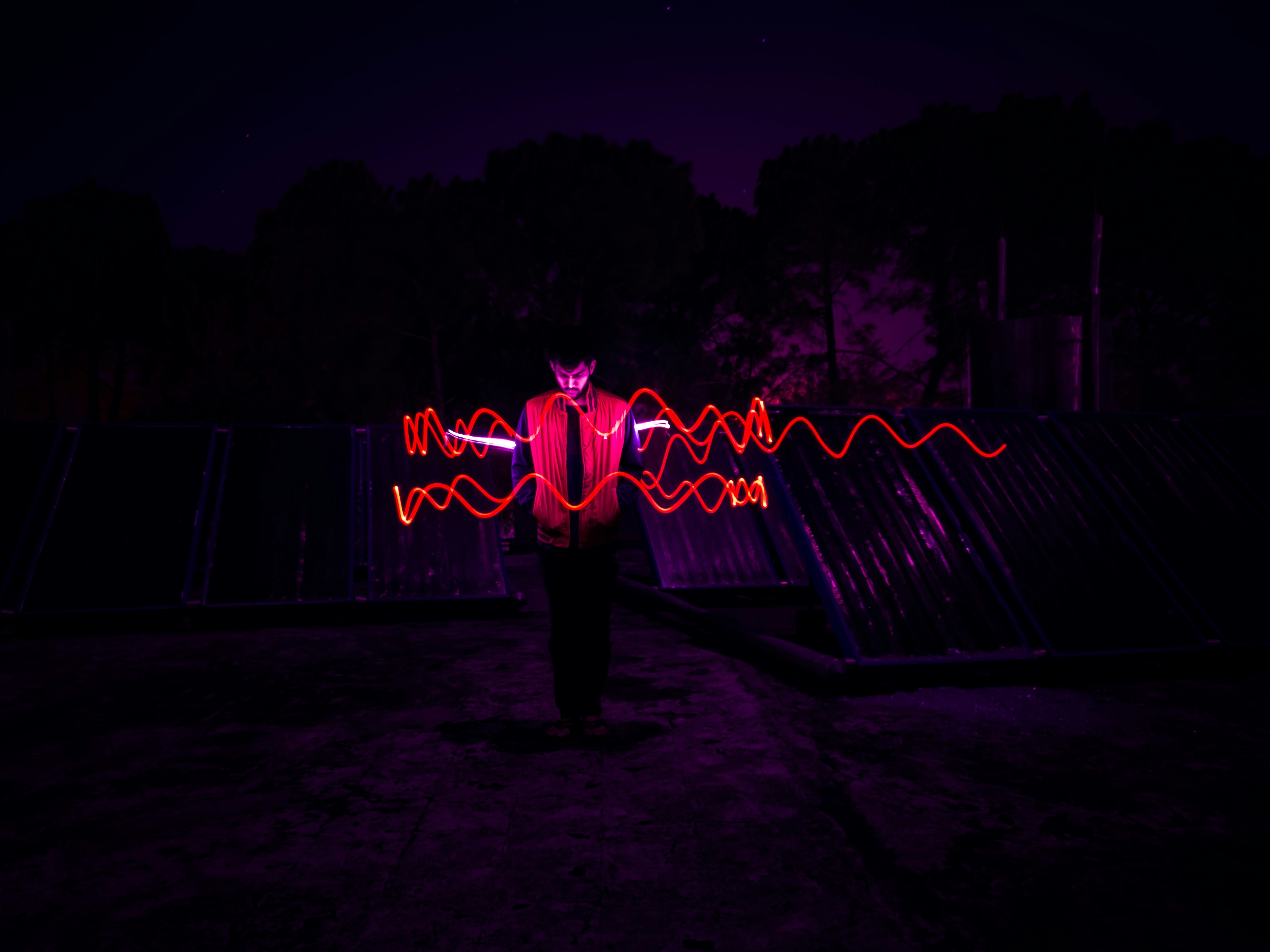man standing in the center of red lights photography