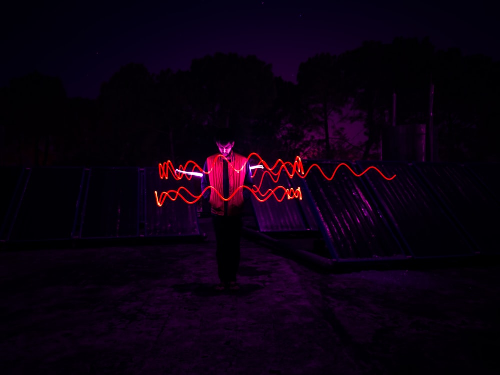 man standing in the center of red lights photography